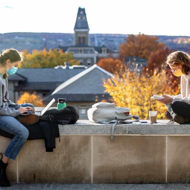 Students wearing masks and studying on an Arts Quad rooftop